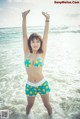 A woman in a bikini standing in the ocean.