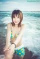 A woman in a bikini standing on the beach.