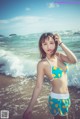 A woman in a bikini standing on the beach.