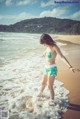 A woman in a bikini standing in the ocean.