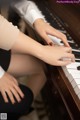 A woman sitting at a piano with her hands on the keys.