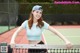 A woman standing on a tennis court holding a tennis racket.