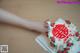 A person holding a cake with a red and white design on it.