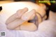 A woman laying on top of a bed with her feet up.