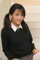 A young woman in a school uniform posing for the camera.