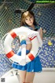 A woman in a sailor outfit holding a life preserver.