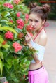 A woman in a white top and pink shorts posing for a picture.