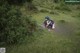 A woman laying on a blanket in the grass.