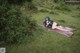 A woman laying on a blanket in the grass.