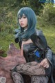 A woman with blue hair sitting on a cowhide rug.