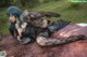 A woman laying on top of a cowhide covered ground.