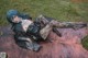 A woman laying on top of a cowhide rug in the grass.