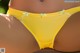 A close up of a woman wearing a yellow panties.