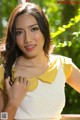 A woman in a yellow and white dress posing for a picture.