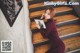 a woman sitting on the stairs holding a book