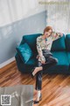 A woman sitting on a blue couch in a room.