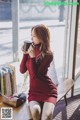 A woman sitting on a table holding a cup of coffee.