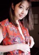 A woman in a red floral dress posing for a picture.