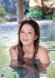 A young woman in a swimming pool smiling at the camera.