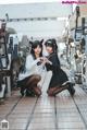 A couple of girls in school uniforms posing for a picture.