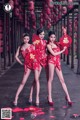 A group of three women in red dresses posing for a picture.