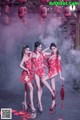 A group of three women in red dresses posing for a picture.