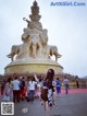 A woman standing in front of a large statue of an elephant.