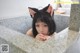 A woman in a bathtub with a cat ears on her head.