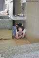 A woman laying on the floor in a bathroom.