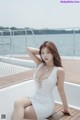 A woman in a white dress sitting on a boat.