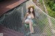 A woman sitting in a hammock on a wooden deck.