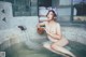 A naked woman sitting in a hot tub with a bowl of water.