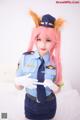 A woman dressed as a police officer with pink hair.