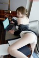 A woman sitting at a desk using a laptop computer.