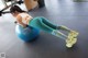 A woman is sitting on an exercise ball in a gym.