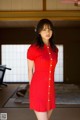 A woman in a red dress standing in a room.