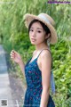 A woman in a blue dress and a straw hat.