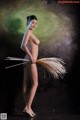 A naked woman holding a broom in her hand.