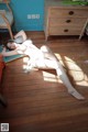 A woman laying on the floor in a white lingerie.