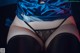 A woman wearing a blue satin top and black stockings.