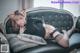 A woman laying on a couch wearing a cat ears headband.