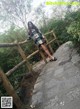 A woman standing on a wooden bridge in a forest.