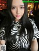 A woman with long black hair wearing a zebra print shirt.