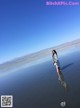 A woman standing in the middle of a body of water.