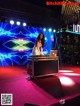 A woman in a silver dress playing a dj set on a stage.