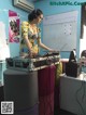 A woman in a yellow dress playing a dj set.