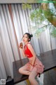 A woman sitting on top of a wooden table holding a drink.