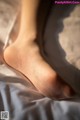 A close up of a person's foot on a bed.