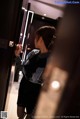 A woman standing in an elevator looking at herself in the mirror.