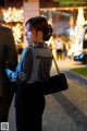 A man and a woman walking down a street at night.